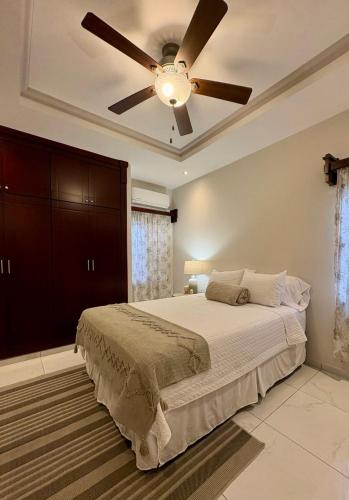 a bedroom with a ceiling fan and a bed at Tu hogar en Casa Valencia in San Pedro Sula