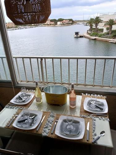 une table sur un balcon avec vue sur l'eau dans l'établissement Appartement 2 chambres dans la marina, à Saint Cyprien Plage