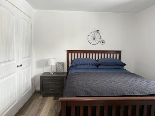 a bedroom with a bed and a nightstand with a bicycle on the wall at Holiday House in Bathurst