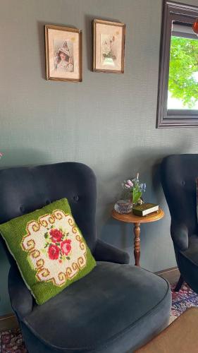 a blue chair with a green pillow in a room at De Verborgen Pracht in Schagen