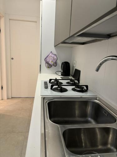 a kitchen with a sink and a stove at Residence Lario Village in Colico