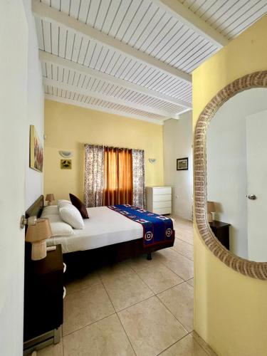a bedroom with a large bed in a room at Bubali Gardens - Eagle Beach's Oasis in Noord