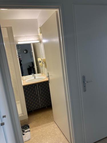 une salle de bain avec un lavabo et un miroir dans l'établissement Rochefort Appartement, à La Celle-sous-Gouzon