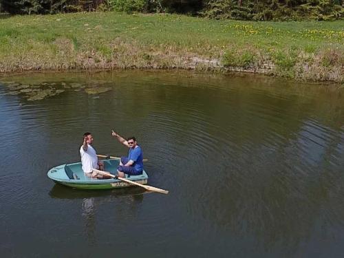 two people are rowing a boat on the water at Pokój Cień Paproci in Białla