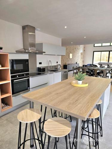 une grande cuisine avec une table et des chaises en bois dans l'établissement La Tremblaie Grange rénovée avec vue campagne - 10 min du Puy duFou, à Châteaumur