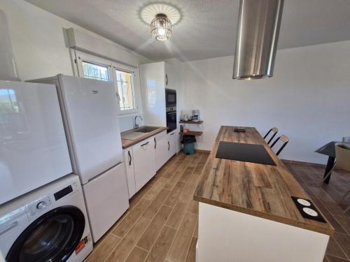 Il comprend une cuisine équipée d'un réfrigérateur et d'une table avec un lave-linge. dans l'établissement Le Luna - Fréjus, à Fréjus