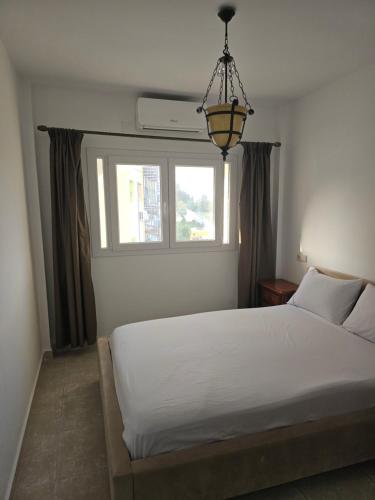 une chambre avec un lit blanc et une fenêtre dans l'établissement Casa Luna, à Tetouan