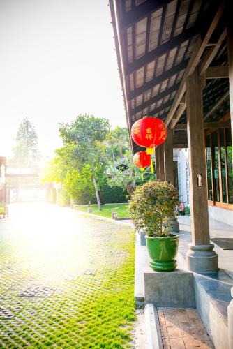 a building with red umbrellas on a brick street at Chu Hotel in Chiang Mai