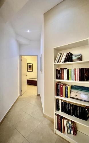 a hallway with book shelves filled with books at Bubali Gardens - Eagle Beach's Oasis in Noord