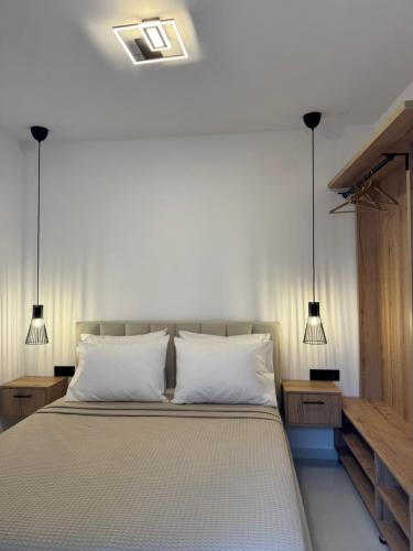 a bedroom with a bed with two lamps on it at Armonia Apartment in Pefkohori