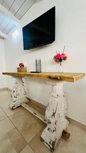 a wooden table with a television on a wall at La Meridiana - centro storico di Pizzo in Pizzo