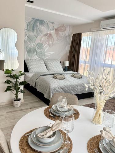 a bedroom with a bed and a table with plates on it at HelloWine Apartman III in Eger