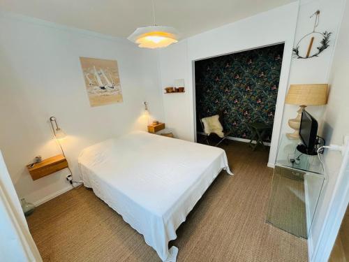 une chambre avec un lit blanc et une télévision dans l'établissement Appartement 2 pièces centre historique du Croisic, au Croisic