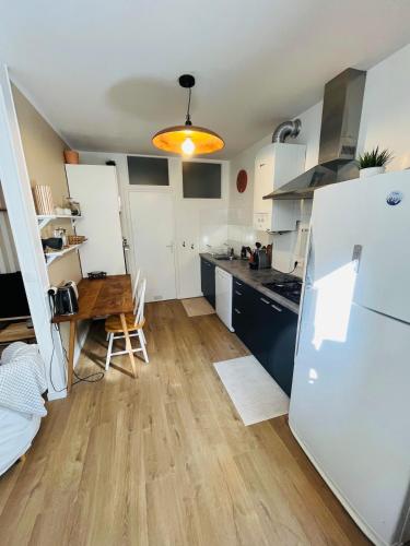 une petite cuisine avec une table et un réfrigérateur dans l'établissement Appartement 2 pièces centre historique du Croisic, au Croisic