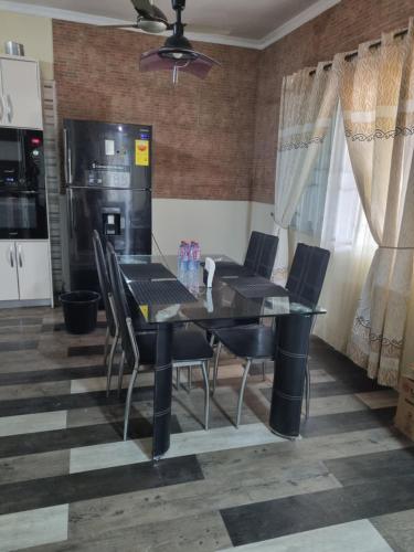 a dining room with a black table and chairs at 2 bedroom house in Tema in Tema