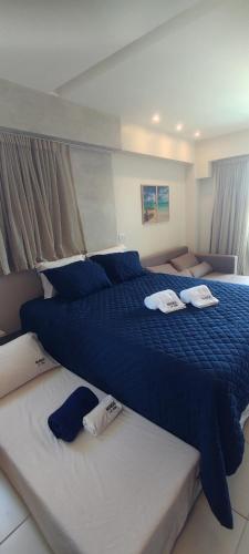 ein Schlafzimmer mit zwei Betten mit blau-weißer Bettwäsche in der Unterkunft Flat Makia Beach Muro Alto, Porto de Galinhas in Ipojuca