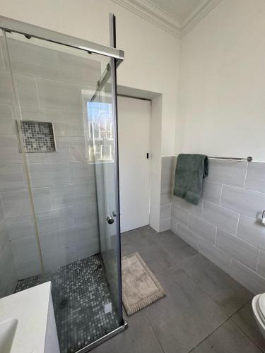 a bathroom with a shower with a glass door at Gladys Suites 2 in Gqeberha