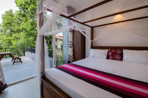 a bedroom with a bed and a balcony at d villa galle in Galle