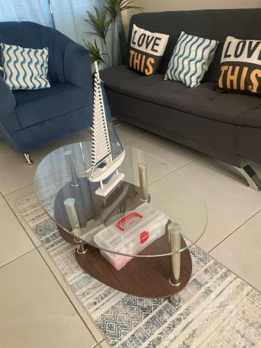a living room with a glass table with a guitar on it at A good rest upon arrival or departure from your trip just 7 minutes from El Salvador's airport in Las Flores
