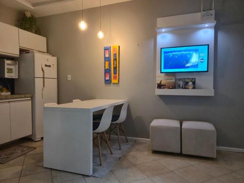 a kitchen with a counter and a tv on the wall at Seu apê no Sal in Salinópolis