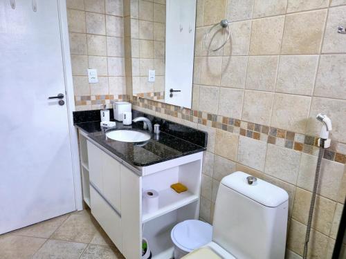 a bathroom with a white toilet and a sink at Seu apê no Sal in Salinópolis