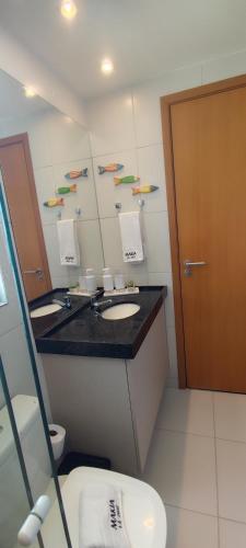 ein Badezimmer mit Waschbecken und Spiegel in der Unterkunft Flat Makia Beach Muro Alto, Porto de Galinhas in Ipojuca