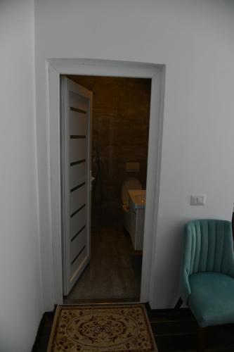 a hallway with a door to a bathroom with a couch at Two Brothers B A&S Hotel Bar & Restaurant in Valbonë