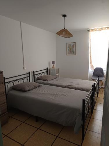 une chambre avec deux lits et une fenêtre dans l'établissement Appartement de village avec grande terrasse, à Malaucène