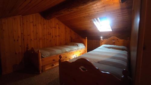 a bedroom with two beds in a wooden cabin at La Baita di Savara - nature and silence in Valsavarenche