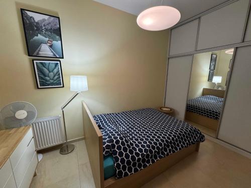 a small bedroom with a bed and a mirror at Studio Wisełka Leśna in Wisełka