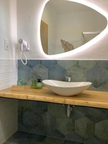 a bathroom with a white sink and a mirror at Tulipán Ház Gyál in Gyál