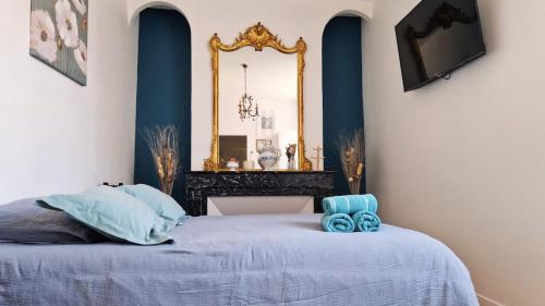 une chambre avec un lit avec un miroir au mur dans l'établissement Au Ptit Bonheur du Lot, centre-ville, calme, vue, jardin, à Espalion