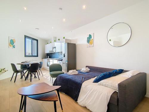 a bedroom with a couch and a table and a kitchen at Suite Evasion - Bel Appartement in Argenteuil
