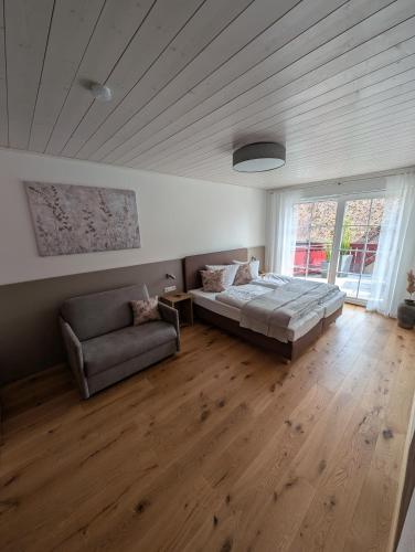 a large bedroom with a bed and a couch at Schwarzer Adler - Ferienwohnung Storchennest in Ipsheim