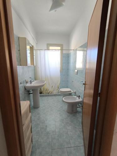 a bathroom with two sinks and a toilet and a shower at casavacanza la vite in Alezio