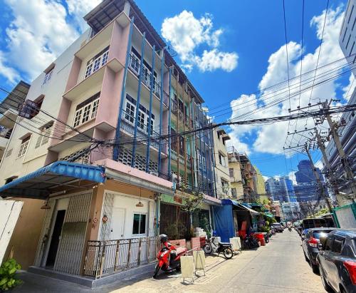 een gebouw in een stadsstraat met een scooter ervoor geparkeerd bij Regalohome Br in Bangkok