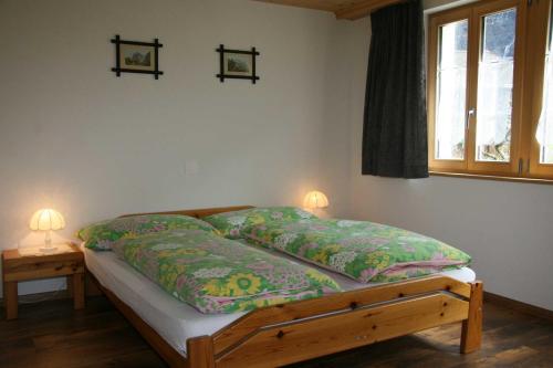 a bed in a bedroom with two lamps on a table at Beim See in Grindelwald