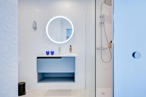 a white bathroom with a sink and a mirror at Hotel Espadon bleu in Le Lavandou