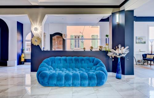 a blue couch in a lobby with a blue sofa at Hotel Espadon bleu in Le Lavandou