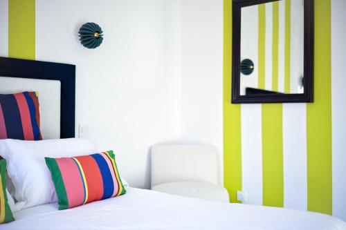 a bedroom with a bed with a mirror and a chair at Hotel Espadon bleu in Le Lavandou