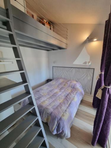 une chambre avec un lit superposé et une échelle dans l'établissement EMPLACEMENT IDEAL, CLIM Appart Maisonnette 4p , au pied de la plage et du Lydia, au Barcarès