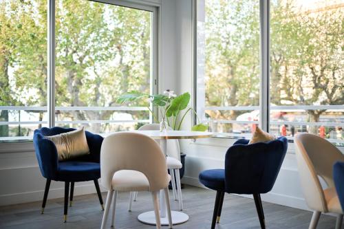 a dining room with a table and chairs and a window at Hotel Espadon bleu in Le Lavandou