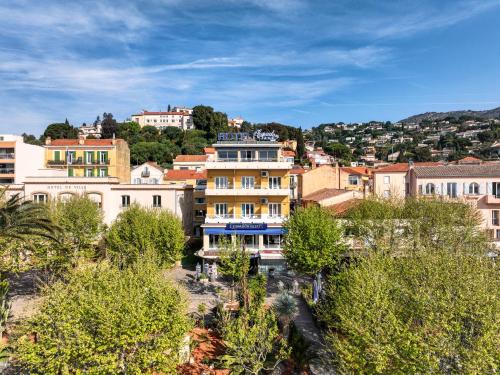 a group of buildings in a city with trees at Hotel Espadon bleu in Le Lavandou
