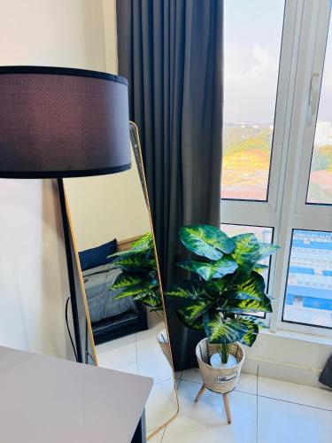 a room with a lamp and a plant next to a window at CHEAPEST PROMO Private Modern King Suites above Mesamall Nilai, 3 Km to USIM in Nilai