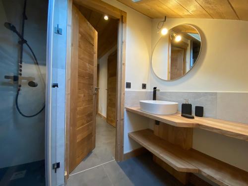 une salle de bain avec un lavabo et un miroir dans l'établissement Les Séracs, à Combloux