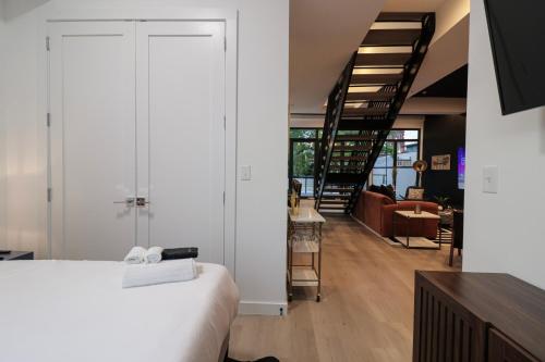a bedroom with a white bed and a staircase at Unit 8 Spacious 2BR Penthouse Sleeps 8 in Washington, D.C.