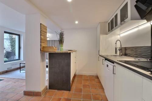 une cuisine avec des armoires blanches et un évier dans l'établissement Superbe maison de vacances-Antibes, à Antibes