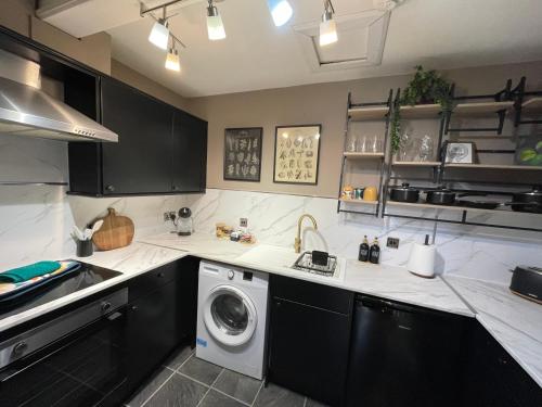 a kitchen with a washer and a washing machine at Spacious and Stylish Flat in the Heart of Hawick in Hawick