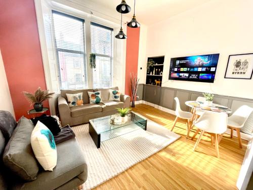 a living room with a couch and a table at Spacious and Stylish Flat in the Heart of Hawick in Hawick