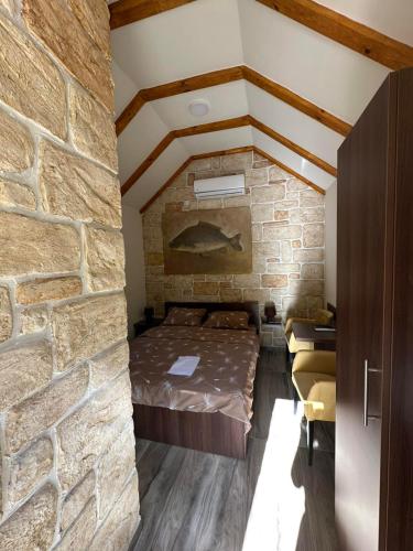 a room with a bed in a brick wall at Prenociste Vranjska banja in Vranjska Banja